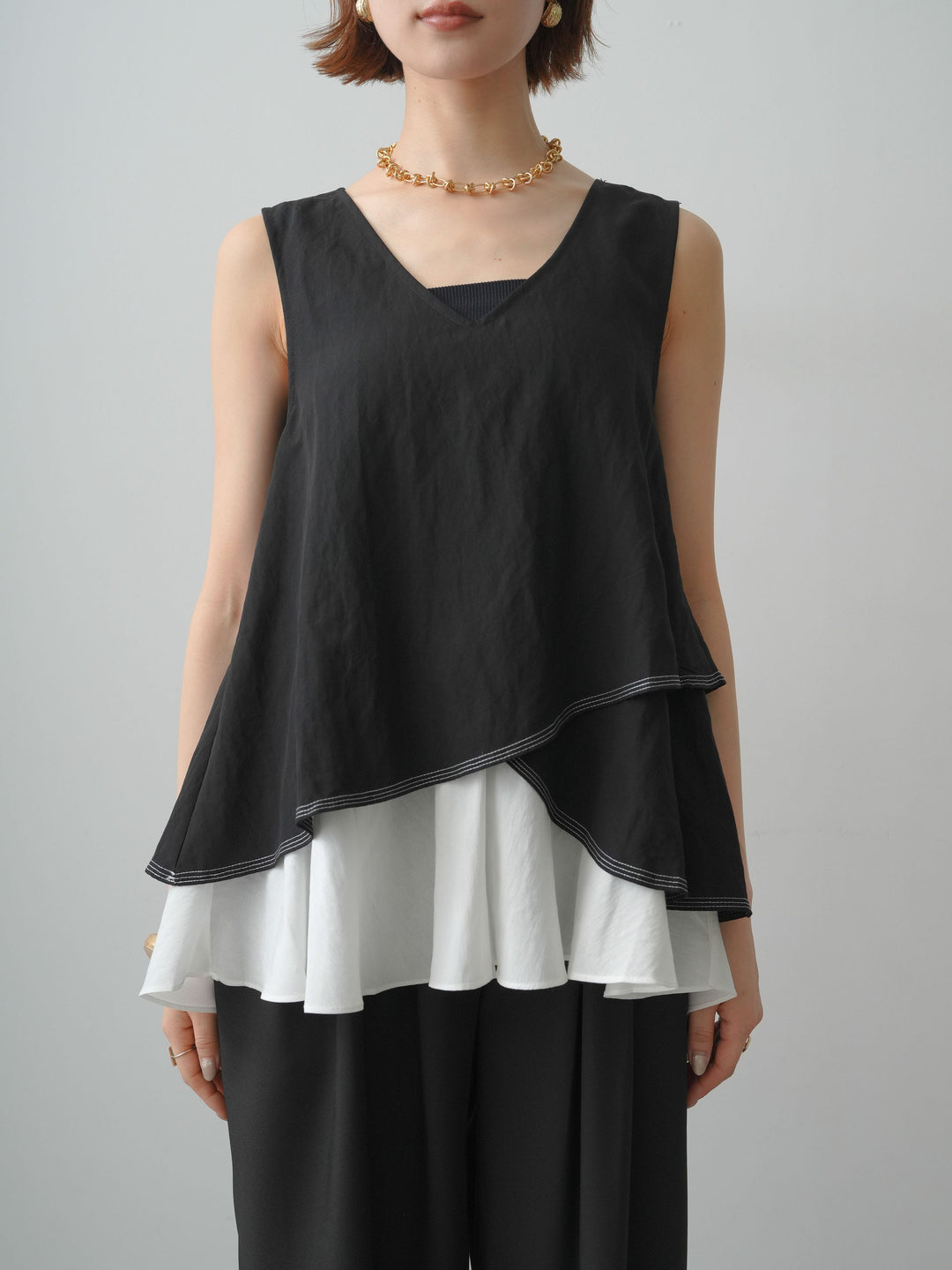 [予約]アシメフリルドッキングステッチノースリブラウス/black